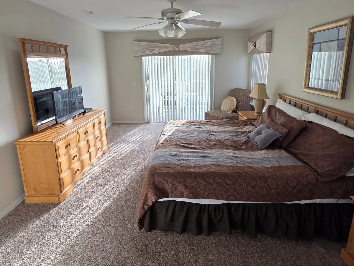King master suite with patio doors, dresser and large windows