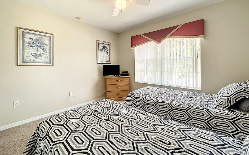 Twin bedroom with geometric bedding and red valance