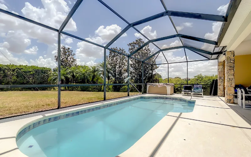 Screened private pool deck with Jacuzzi and seating area